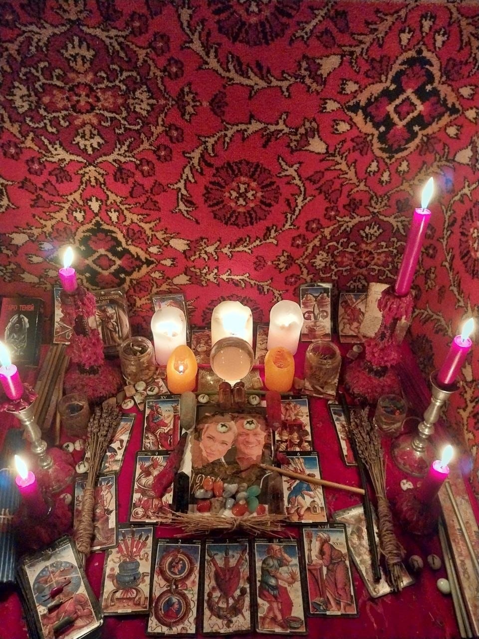 Altar de retorno de pareja con fotos de la pareja, runas sobre las fotos, velas encendidas, hierbas, tarot dispuesto y elementos del ritual